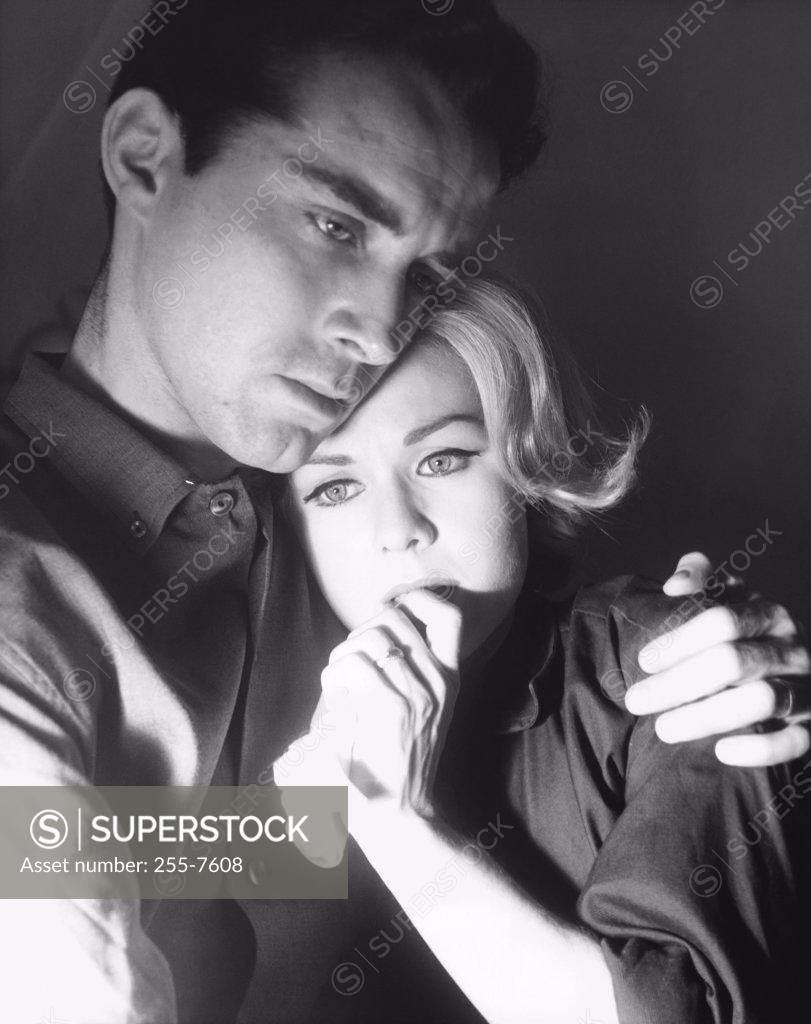 Stock Photo: 255-7608 Close-up of a young man embracing a young woman and looking serious
