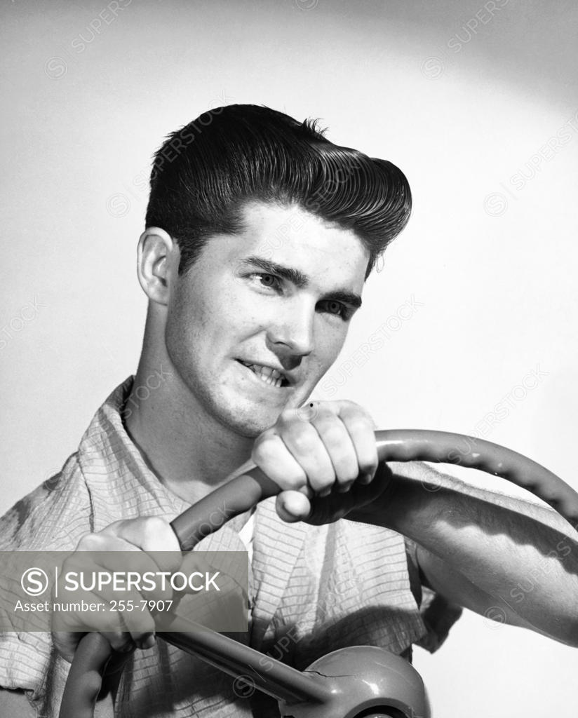 Stock Photo: 255-7907 Close-up of a young man holding a steering wheel