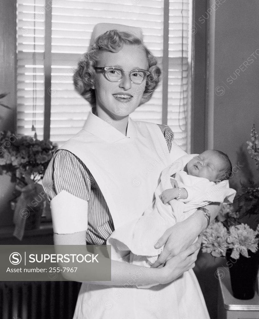 Stock Photo: 255-7967 Portrait of a female nurse carrying a newborn baby boy