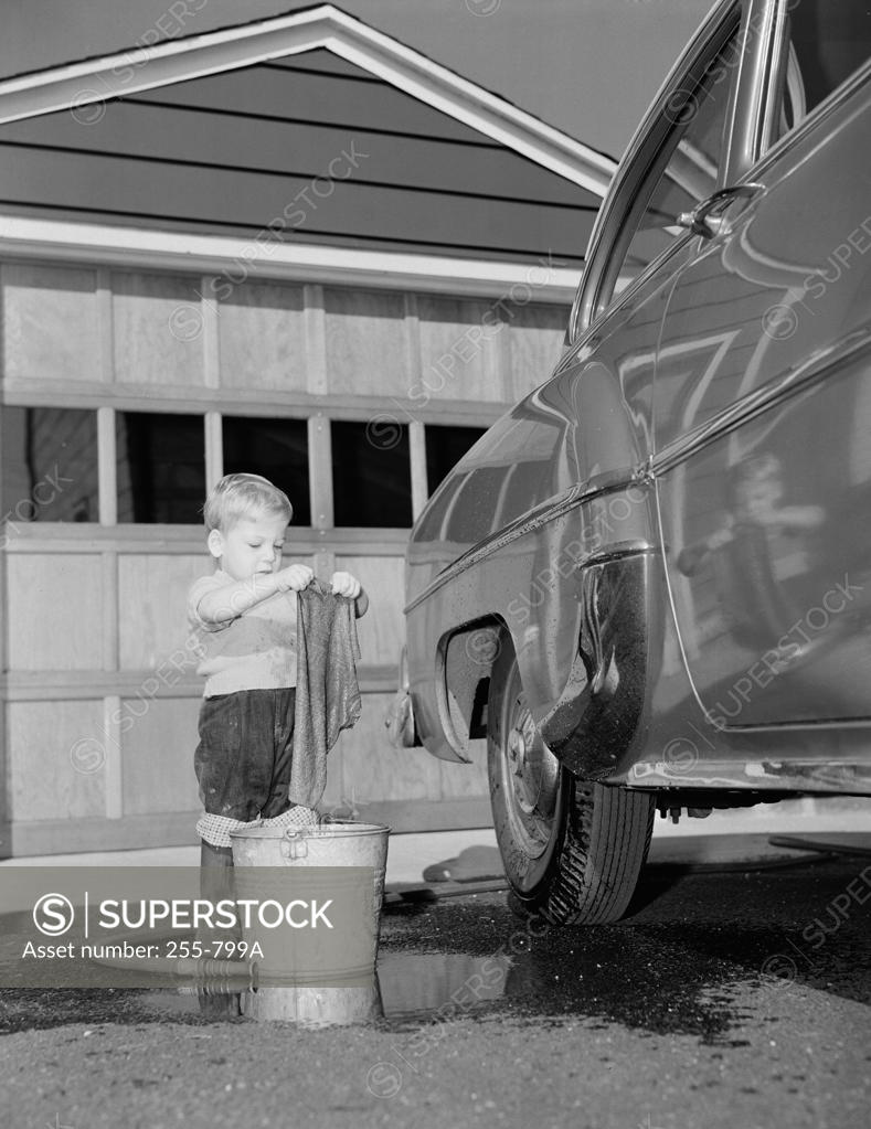 Stock Photo: 255-799A Boy washing car in front of house