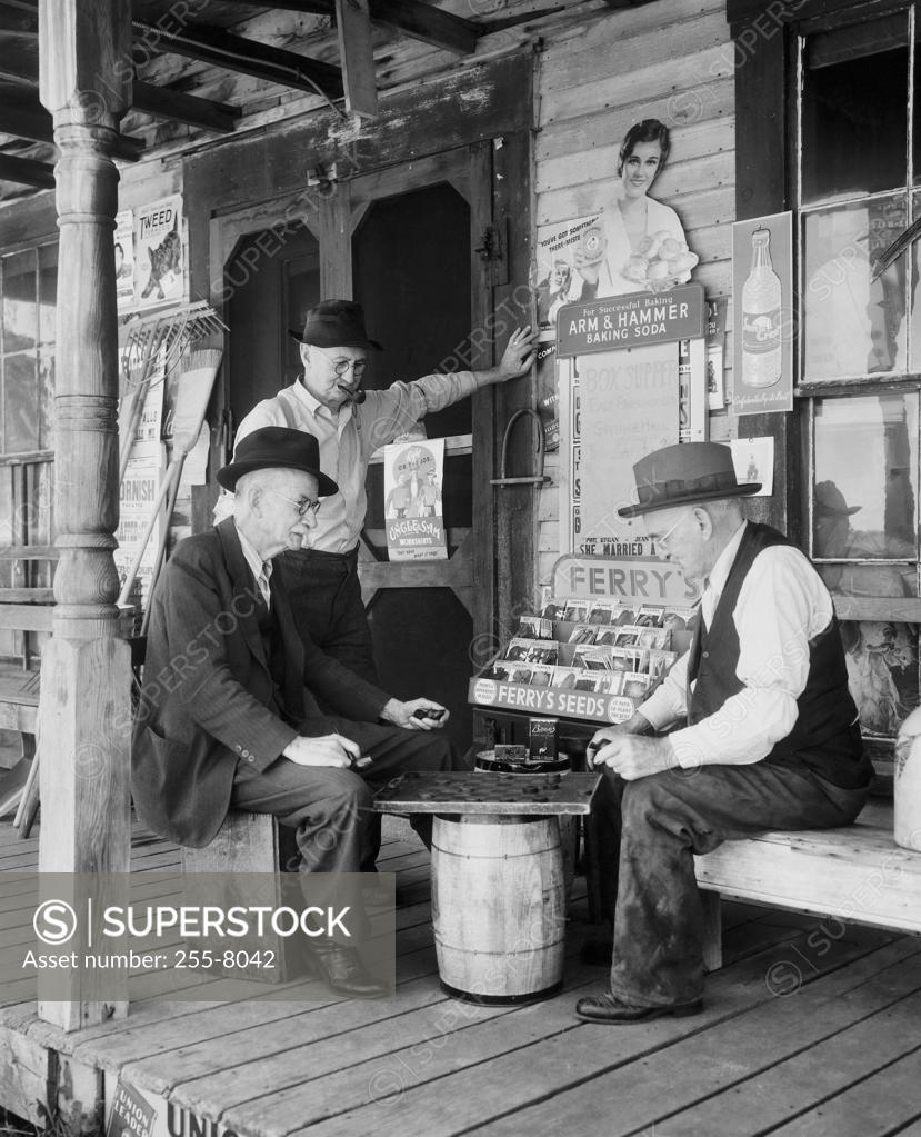 Stock Photo: 255-8042 Side profile of two mature men playing checkers and another mature man standing beside them, Maine, USA