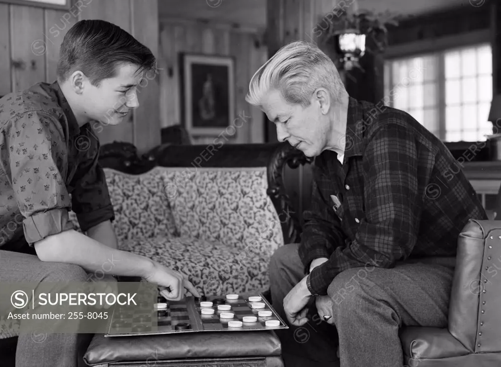Father and his son playing checkers