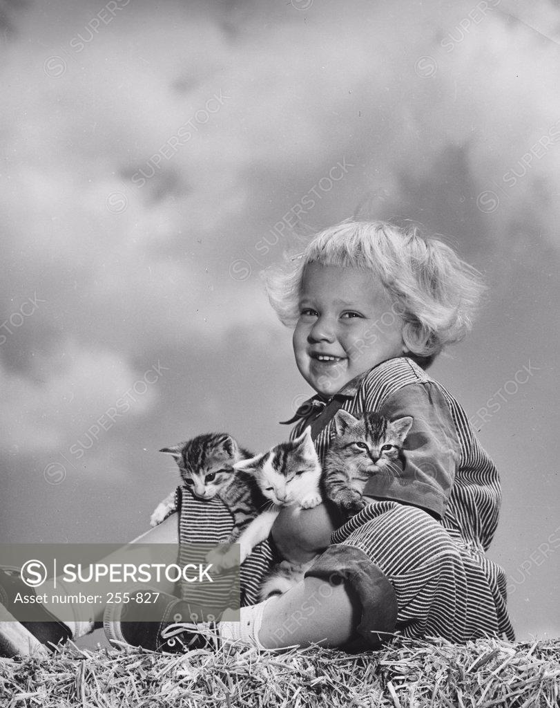 Stock Photo: 255-827 Low angle view of a girl sitting with three kittens