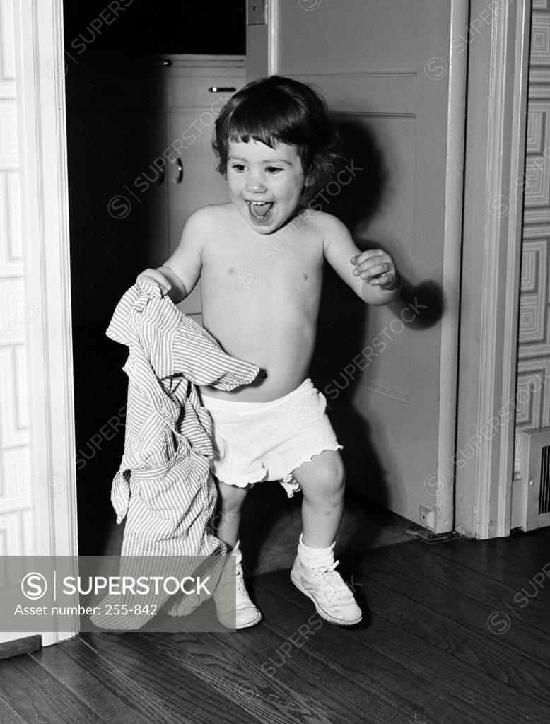 Stock Photo: 255-842 Boy holding shirt in home