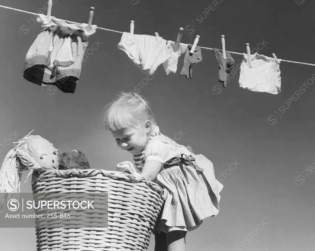 Stock Photo: 255-846 Side profile of a girl looking into a laundry basket