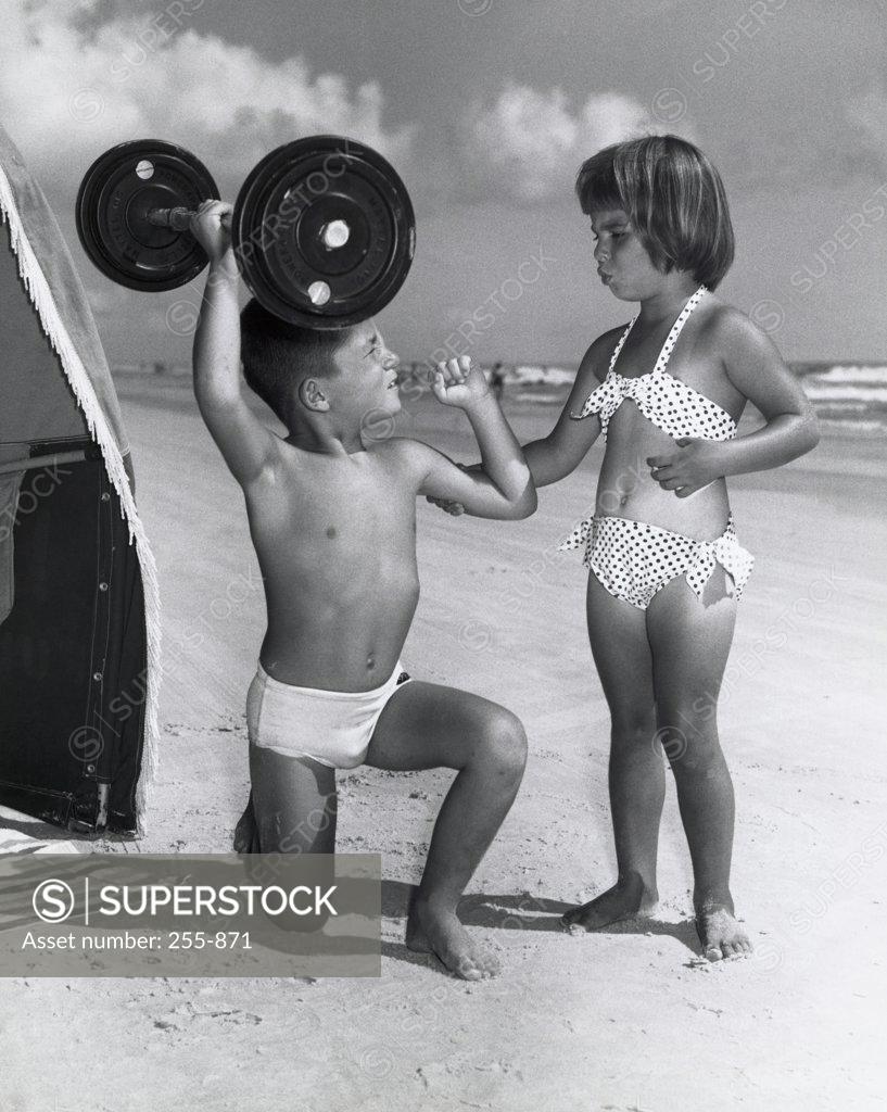 Stock Photo: 255-871 Boy and girl looking at each other on the beach