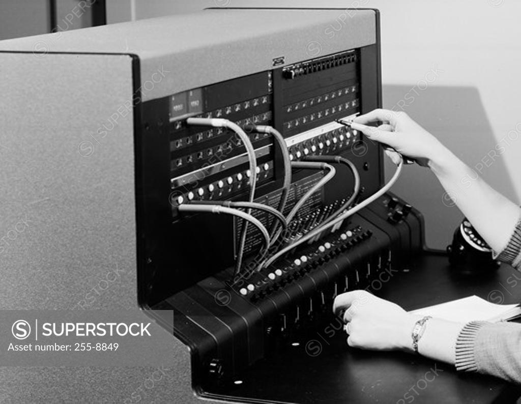 Stock Photo: 255-8849 Close-up of a woman's hand operating a telephone switchboard