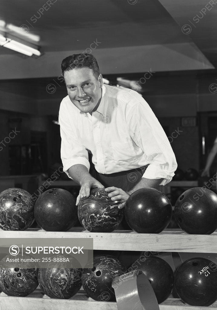 Stock Photo: 255-8888A Young adult man choosing bowling ball