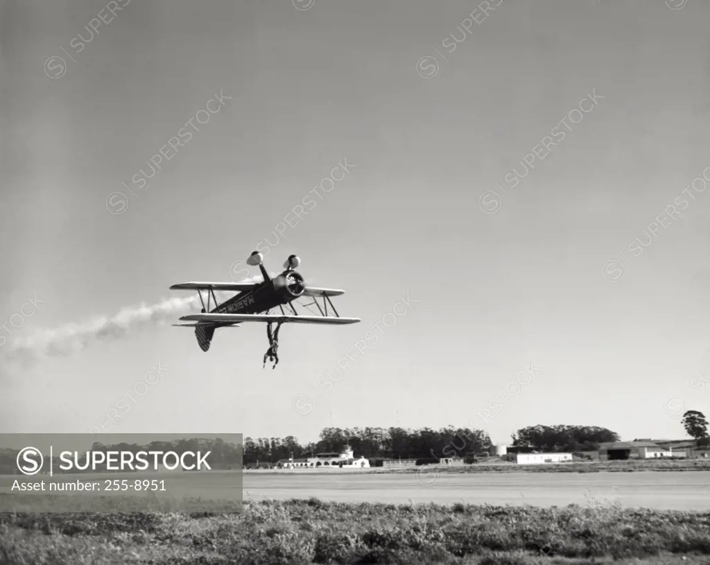 Low angle view of an aircraft upside down in flight with wing walker