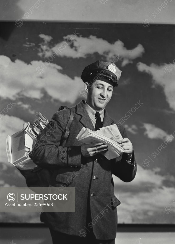 Stock Photo: 255-9068 Low angle view of a postman holding mail