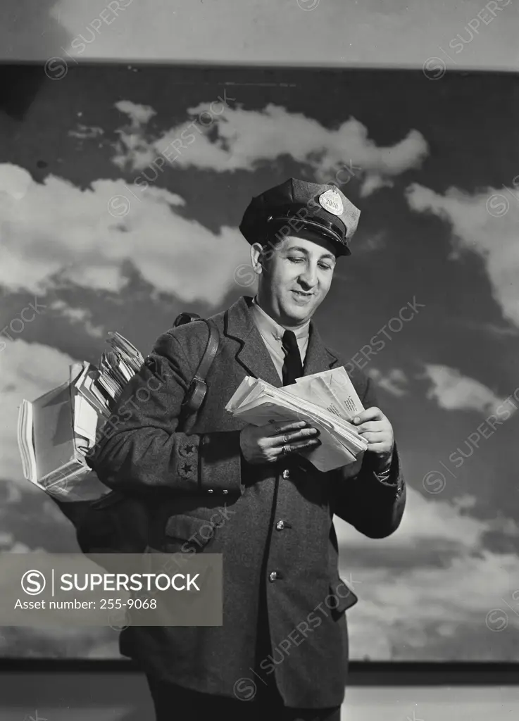Low angle view of a postman holding mail