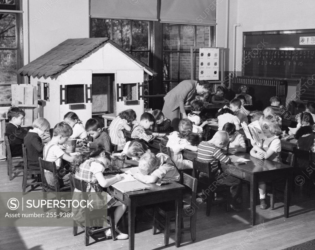 Stock Photo: 255-9389 School children studying in a classroom with their teacher