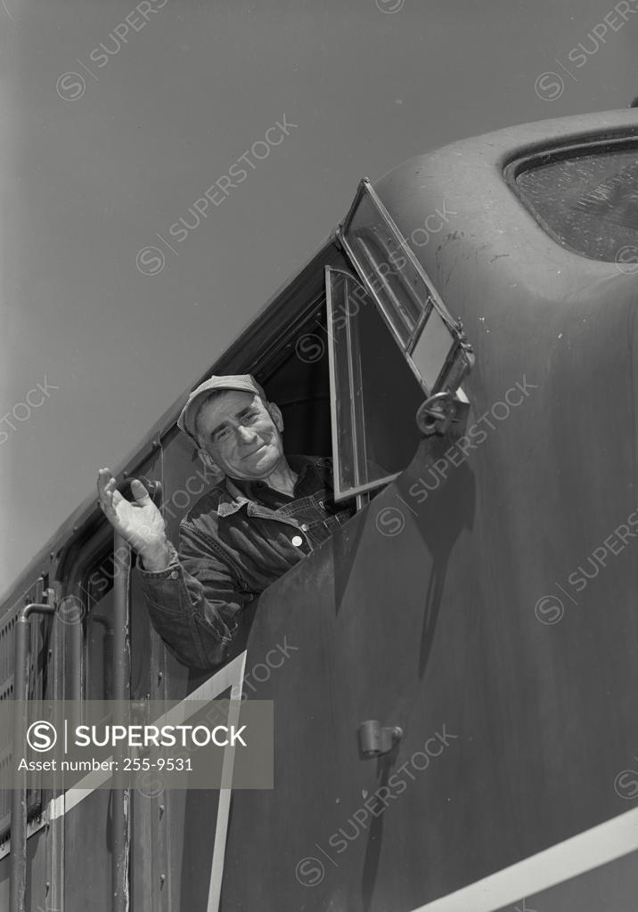 Stock Photo: 255-9531 Low angle view of a train conductor smiling and waving