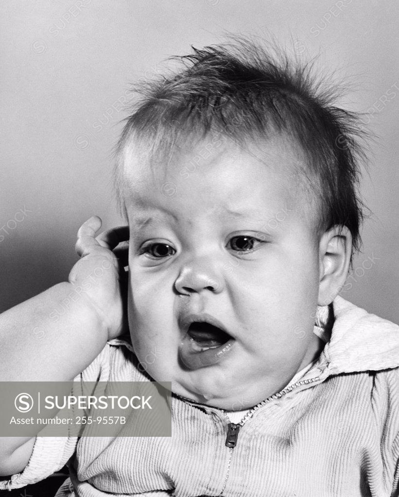 Stock Photo: 255-9557B Baby touching his temple and yawning