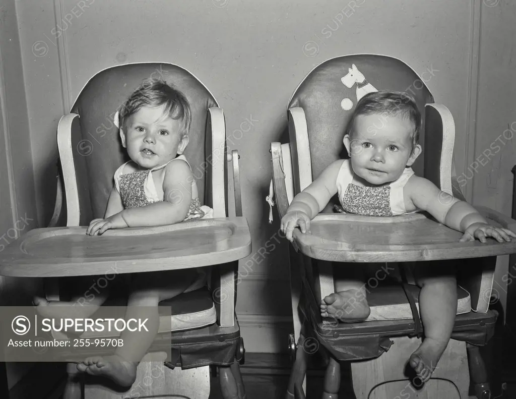 Vintage Photograph. Babies sitting next to each other in high chairs