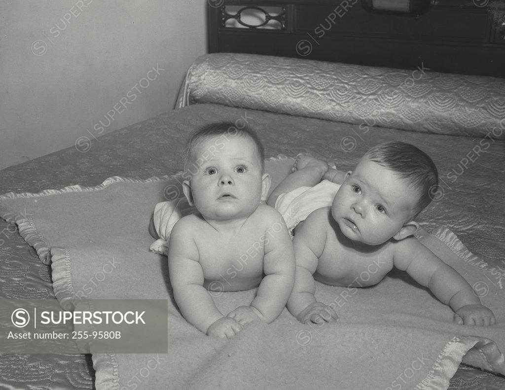 Stock Photo: 255-9580B two babies lying on bed