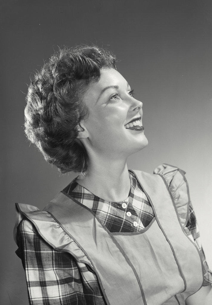Close-up of a young woman in apron smiling