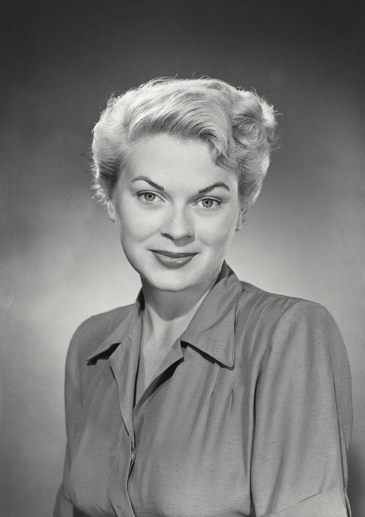 Portrait of woman with blonde hair and closed mouth smile