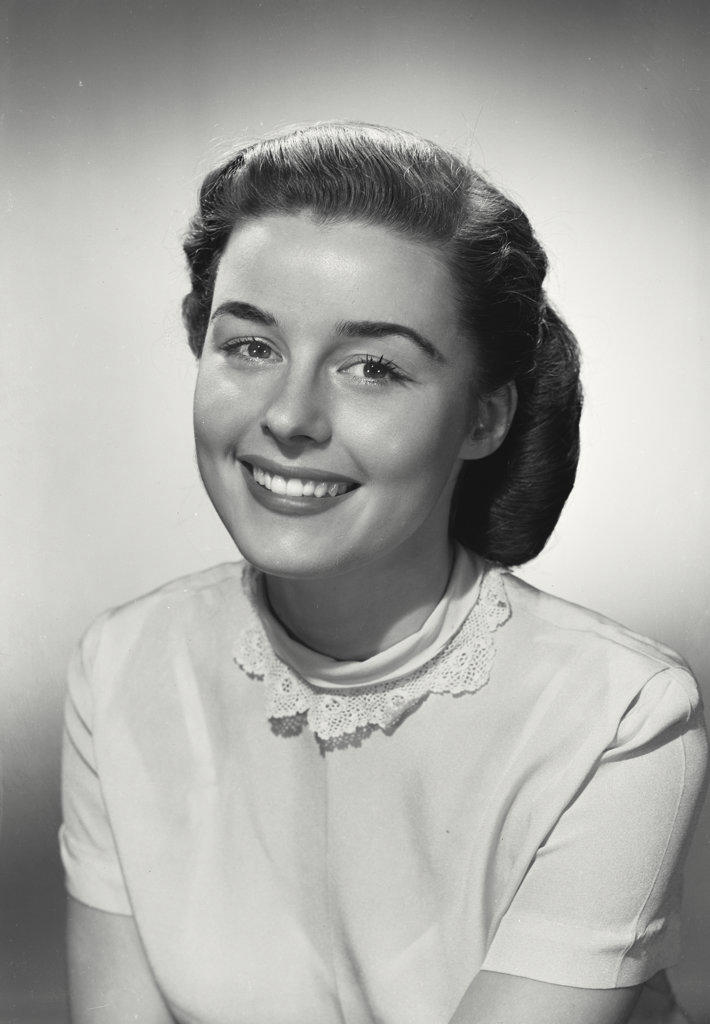 Woman in blouse with lace collar smiling at camera