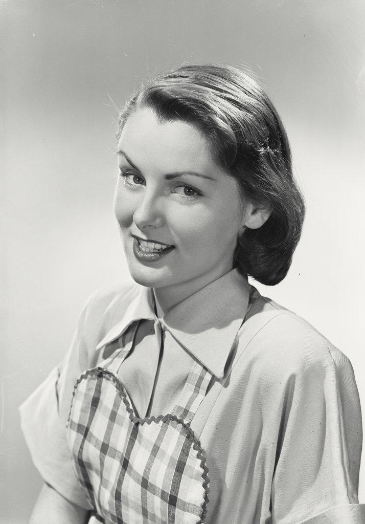 Portrait of woman wearing tartan apron smiling