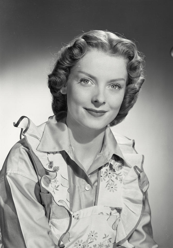 Woman in flower apron smiling at camera