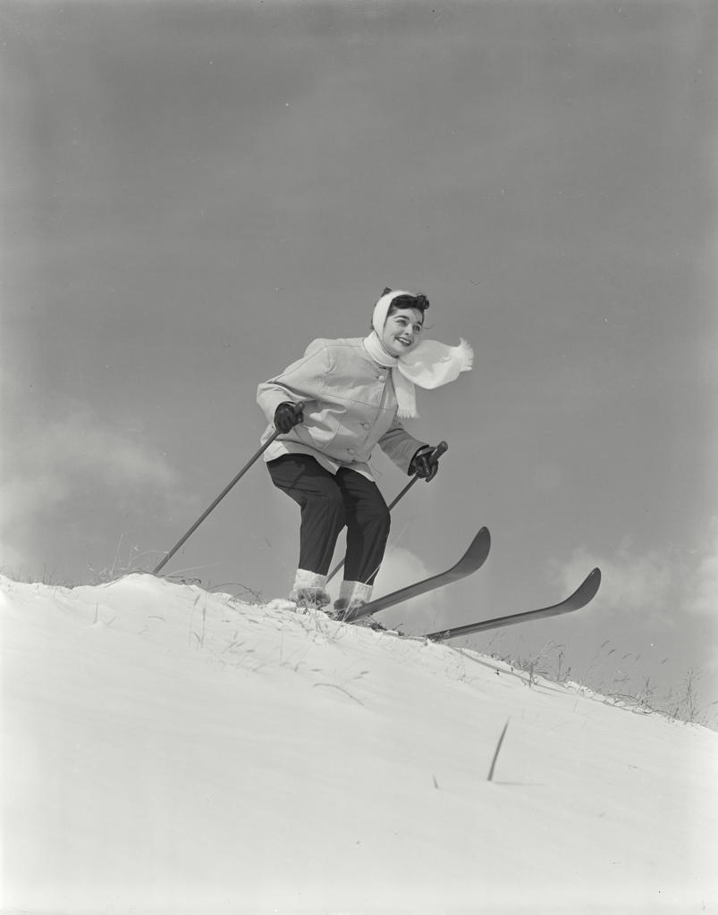 Low angle view of a young woman skiing downhill