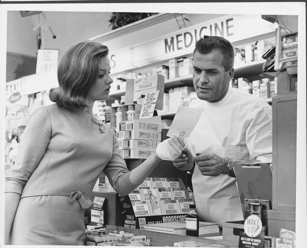 Mid adult woman discussing a prescription with a pharmacist