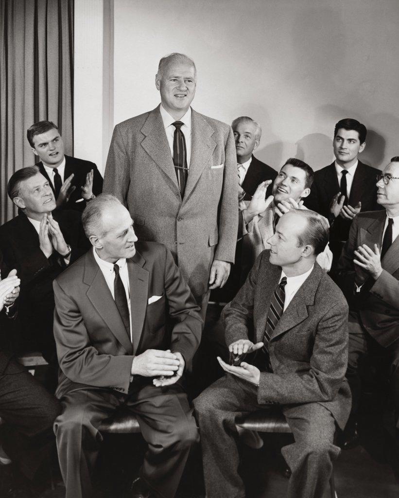 Group of businessmen applauding their colleague