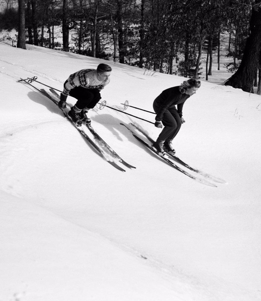 Low angle view of a young couple skiing downhill