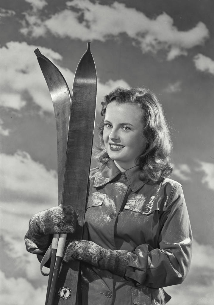 Portrait of a young woman holding skis
