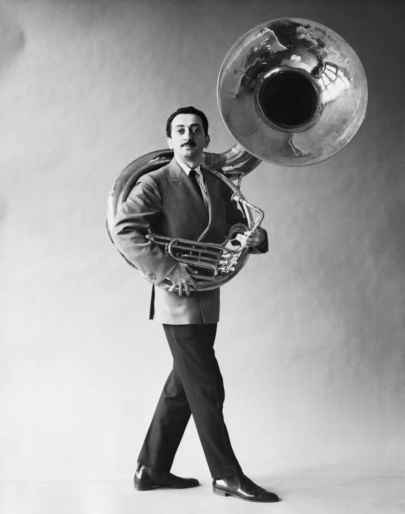 Portrait of mid adult man carrying a tuba