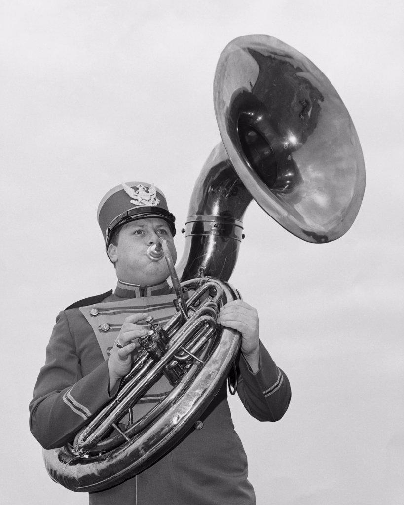 Low angle view of a young man playing the tuba