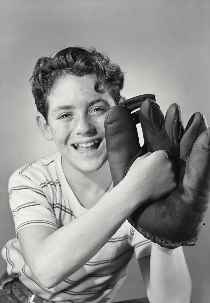 Boy smiling punching center of baseball glove