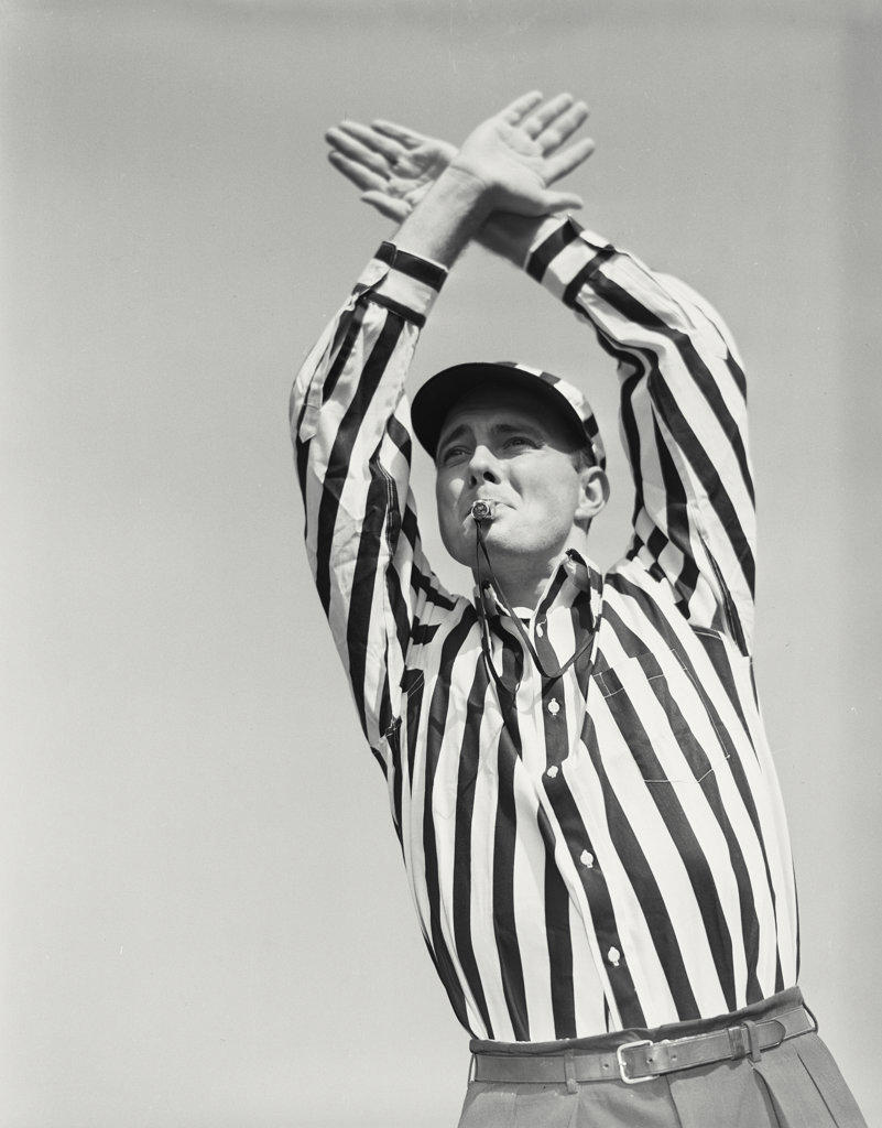 Football referee showing time out signal