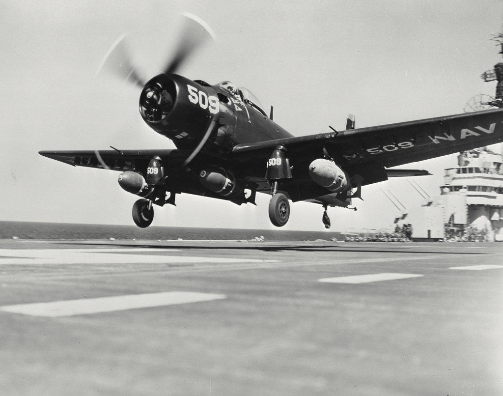 A Navy "Skyraider" armed with three 1,000 pound bombs takes off from the USS Valley Forge