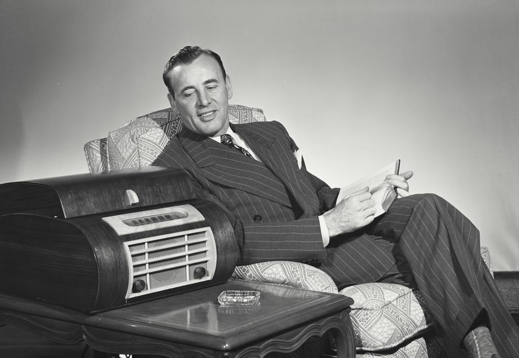 Mid adult man sitting in an armchair and listening to music