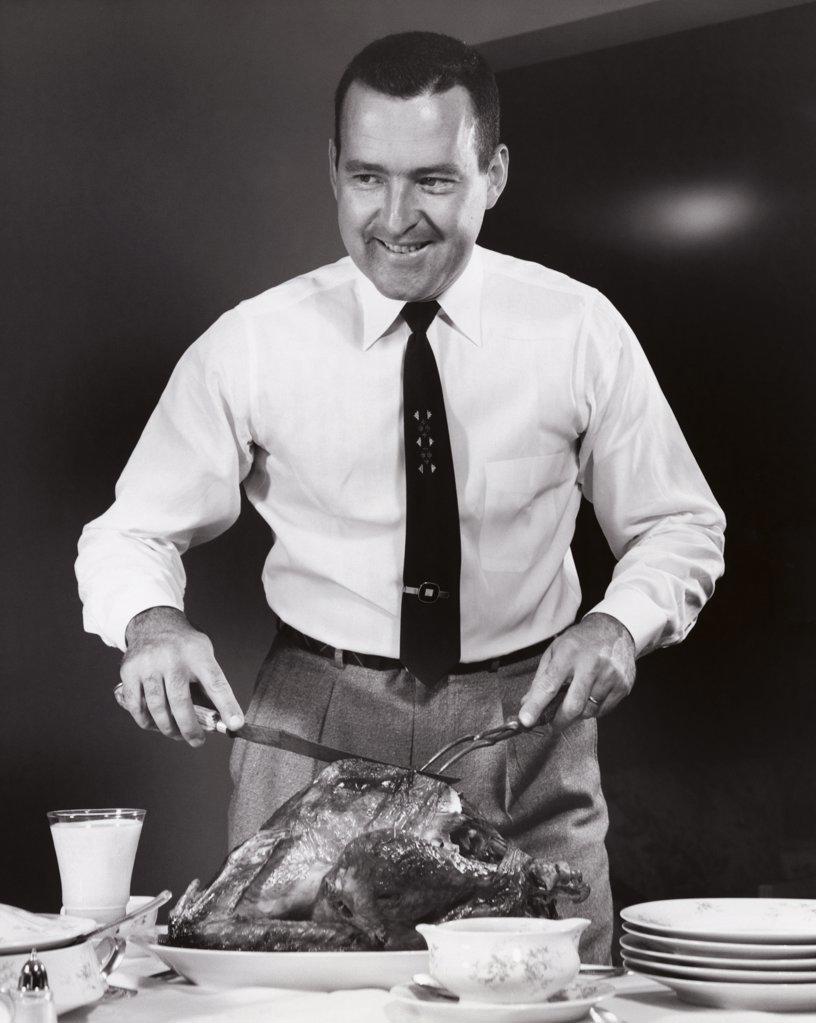 Mid adult man carving a turkey