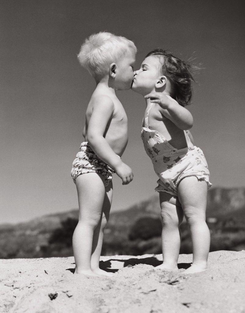 Toddlers kissing on the beach