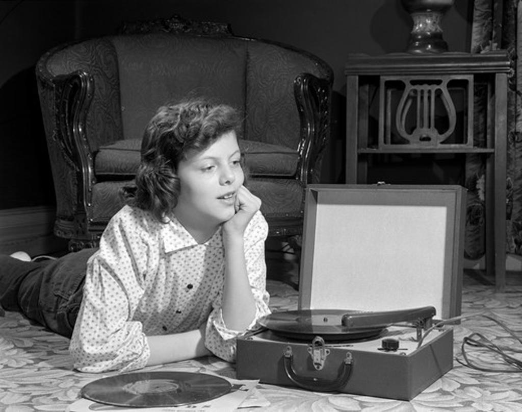 Girl Listening To Record Player On Floor In Home Stock
