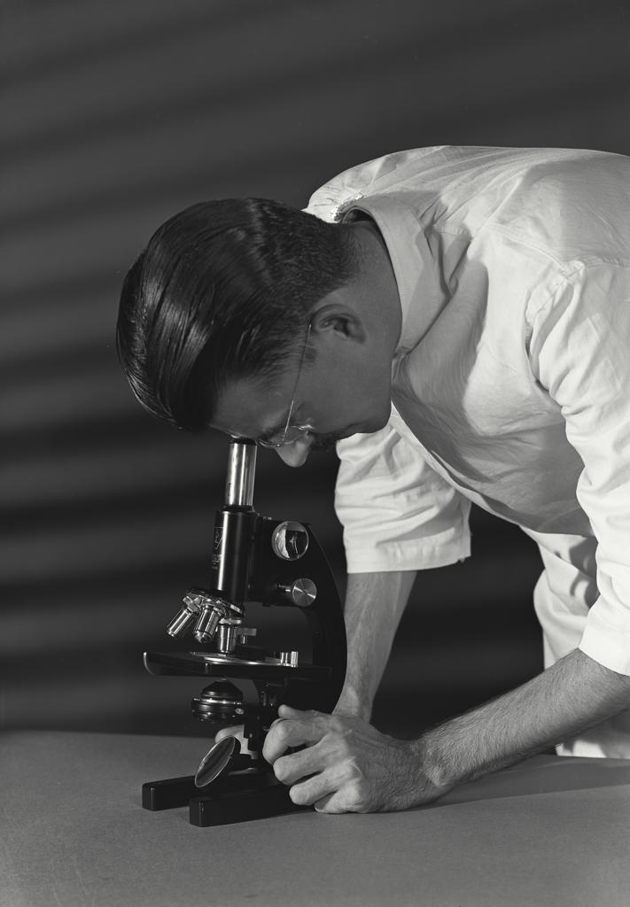 Close-up of a scientist looking through a microscope