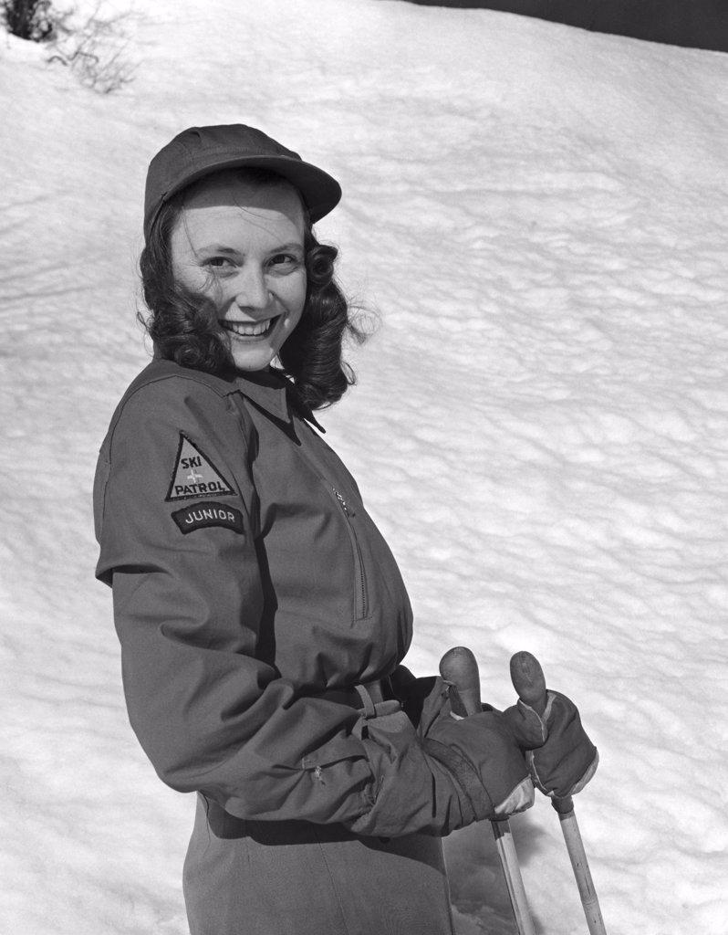 Young woman holding ski poles and smiling