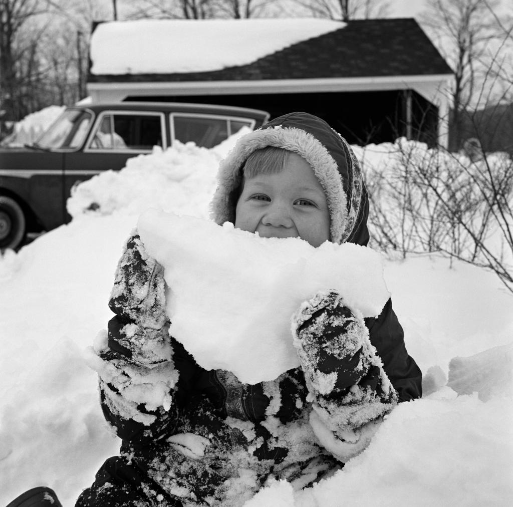 Girl holding pile of snow, portrait