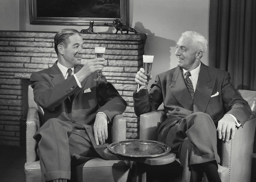 Two mature men toasting with beer glasses