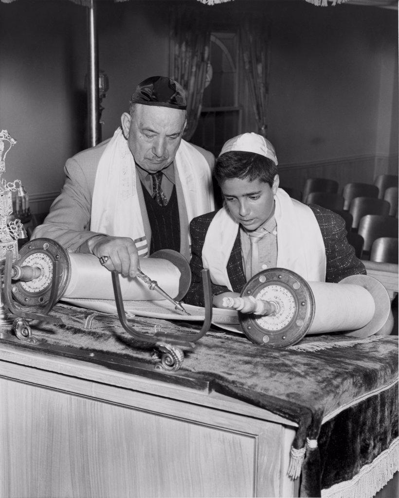 Rabbi and boy reading from torah at bar mitzvah