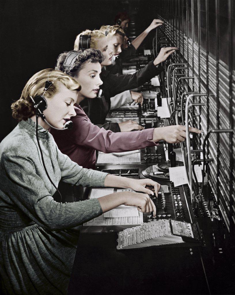 Side profile of group of telephone operators operating switchboards