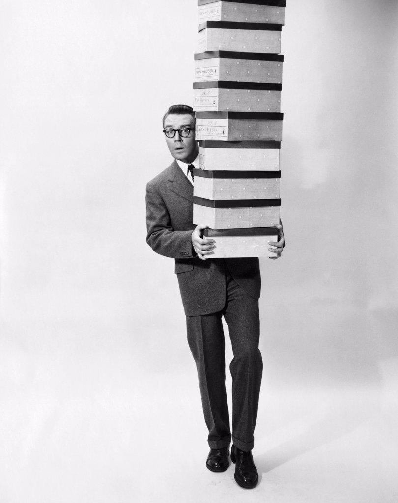 Portrait of a businessman carrying a stack of boxes