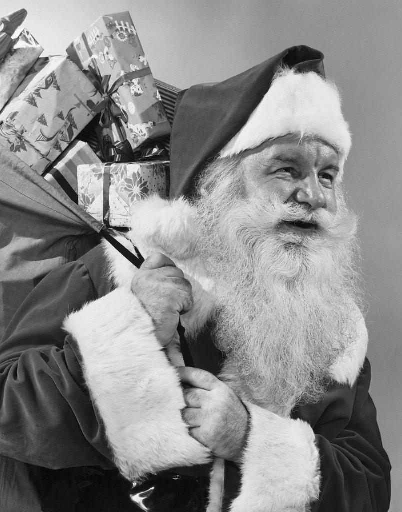 Close-up of Santa Claus carrying a sack of Christmas presents on his back