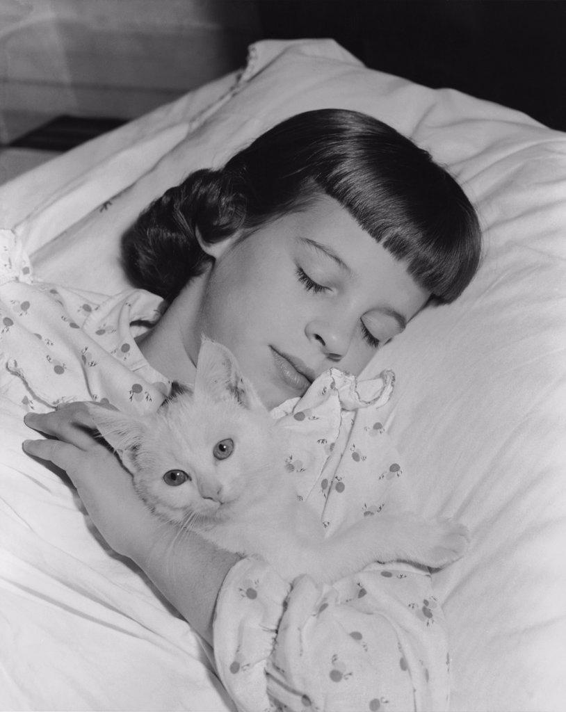 Close-up of a girl sleeping with a cat