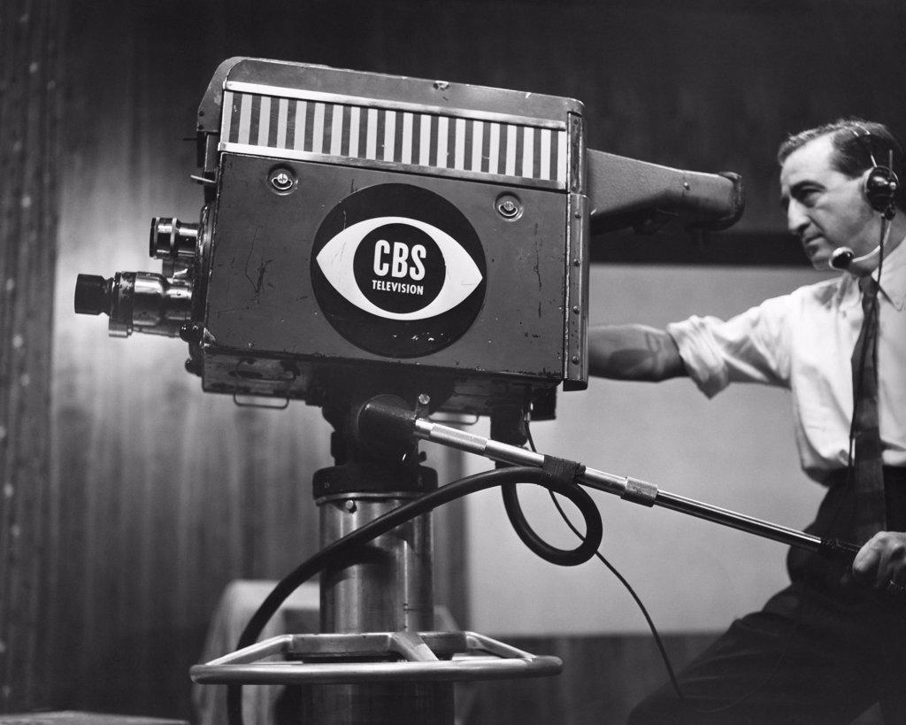 Side profile of a cameraman shooting in a television studio
