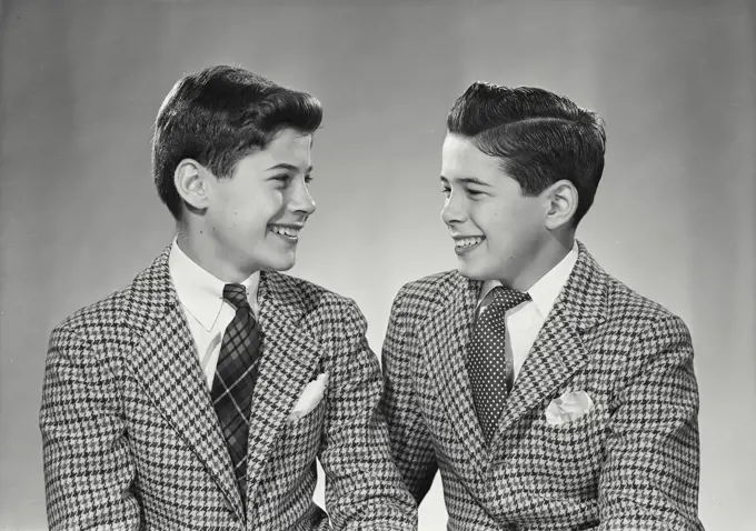 Vintage Photograph. Two boys in suits smiling at each other